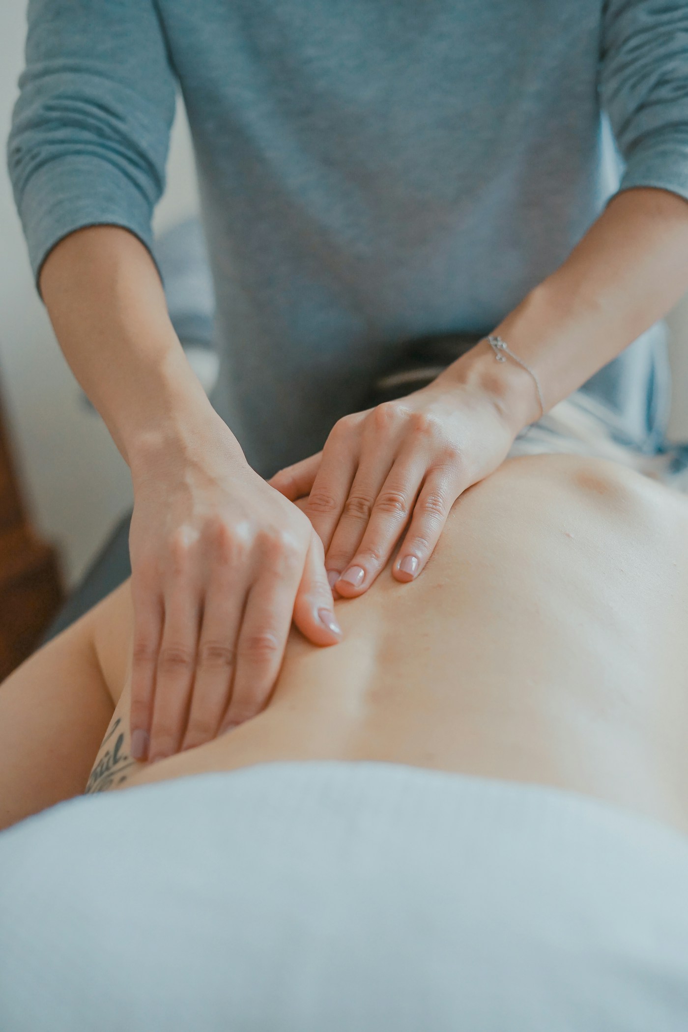 Manos realizando un tratamiento manual de espalda; fotografía de referencia